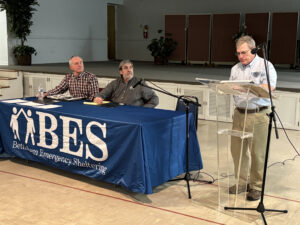 BES Board of Directors Chair Gary Dologite (right) speaks at the BES meeting, while board Treasurer Michael Long and Secretary Robert Hintze (seated, left to right) listen to his report