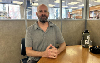 A man seated at a table in a library room